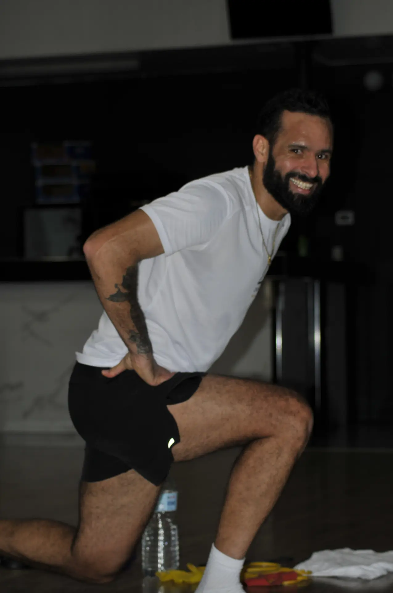 Coach Saief souriant en fente pendant une démonstration d'exercice