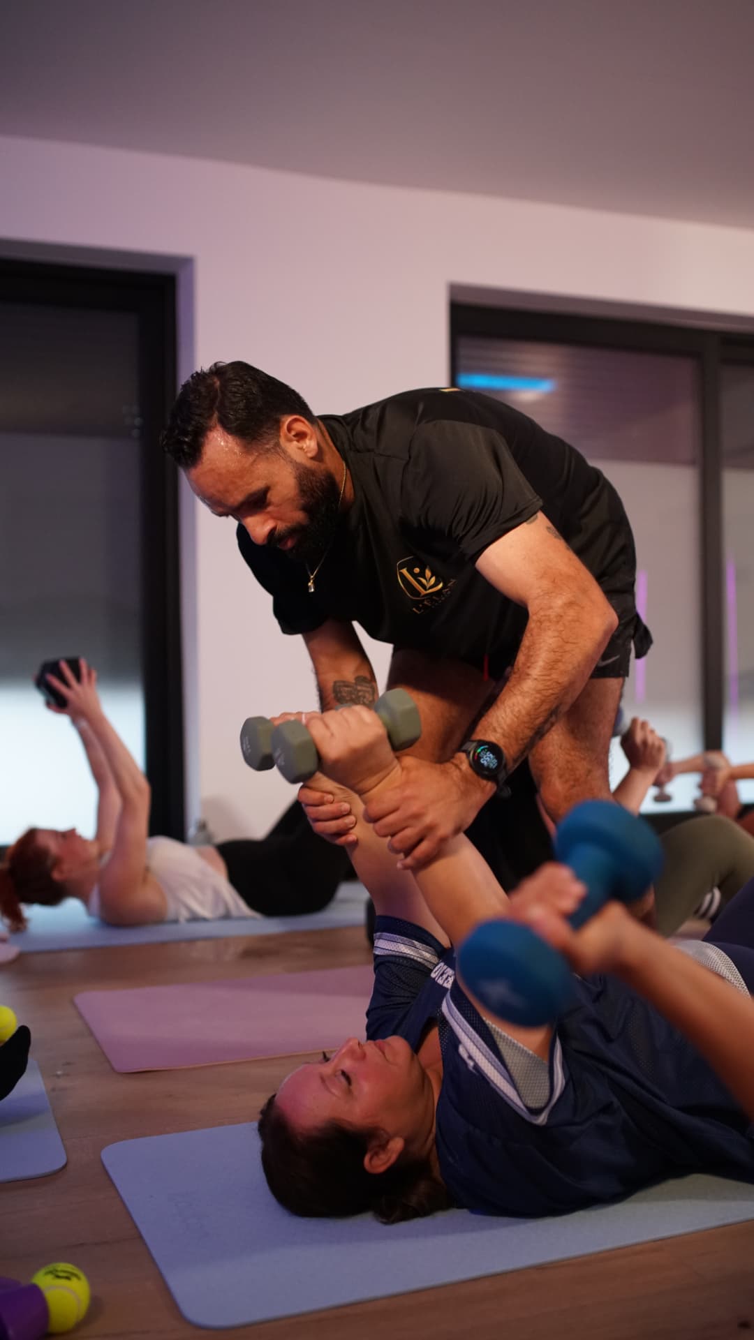 Coach Saief corrigeant le mouvement d'une cliente pendant une séance au studio L'ÉLAN à Maurage