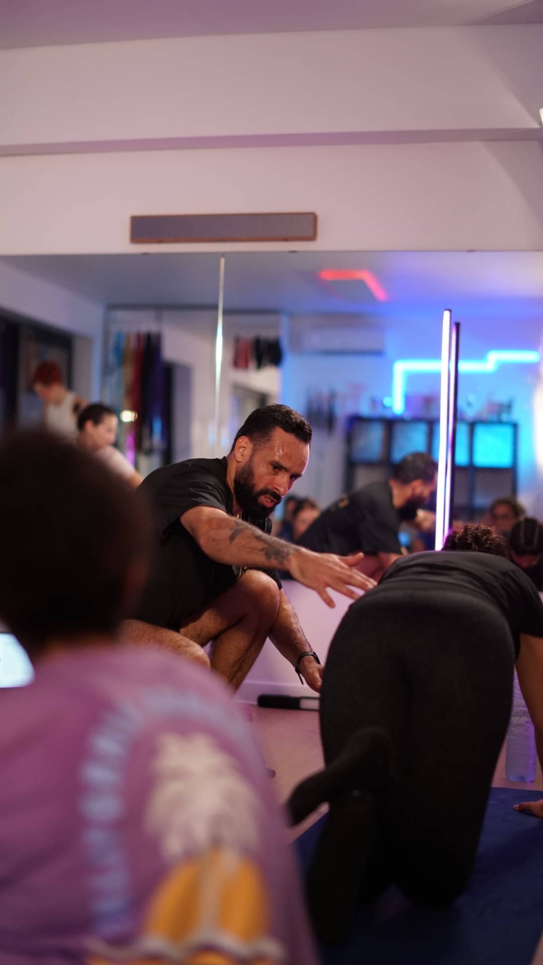 Coach Saief guidant une participante pendant un entraînement au studio L'ÉLAN à Maurage
